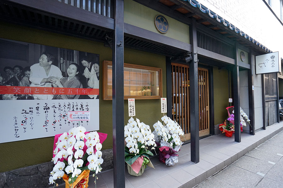 店の外には初代村井夫妻の笑顔の写真が掲げられている。開店祝いのランの花を嬉しそうに見守っているようだ。