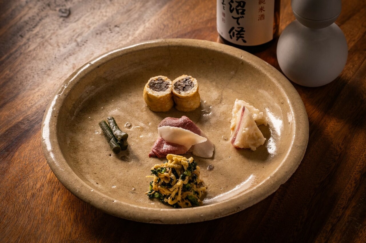 発酵食の珍味。ゼンマイの信田巻き、ウドの塩漬け、猪のハム、ブリと大根のなれずし、切干大根のごま和えを盛り付けたひと皿。