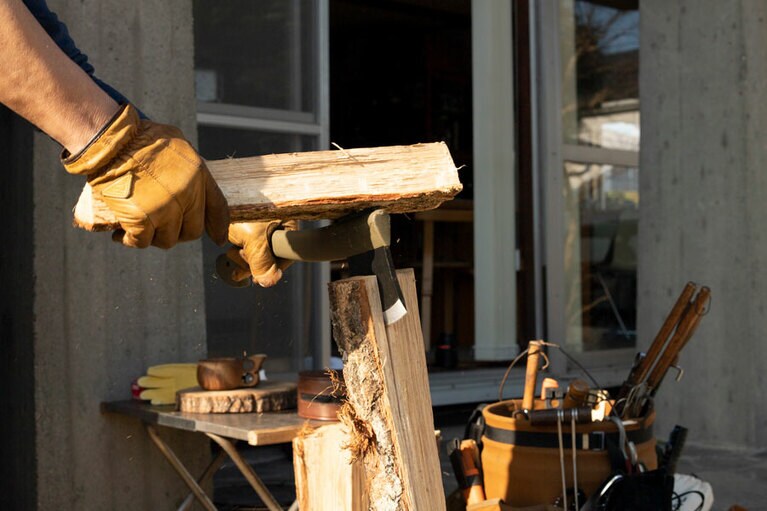 割りたい箇所に斧の刃をあて、薪などを使って斧の背をたたく。