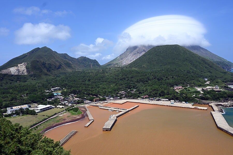 フェリーが入港する硫黄島港。火山島ならではの雲が硫黄岳にかかっています。