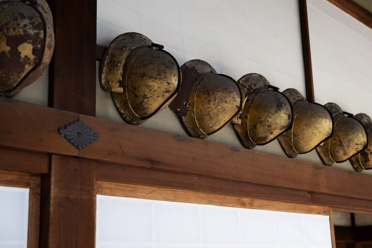安土桃山時代の家臣の金箔押桃形兜が広間の前にずらりと並ぶ。