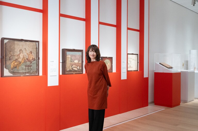 「テルマエ展」会場（パナソニック汐留美術館）にて。作品を観ながら古代ローマの食事情について解説するヤマザキさん。