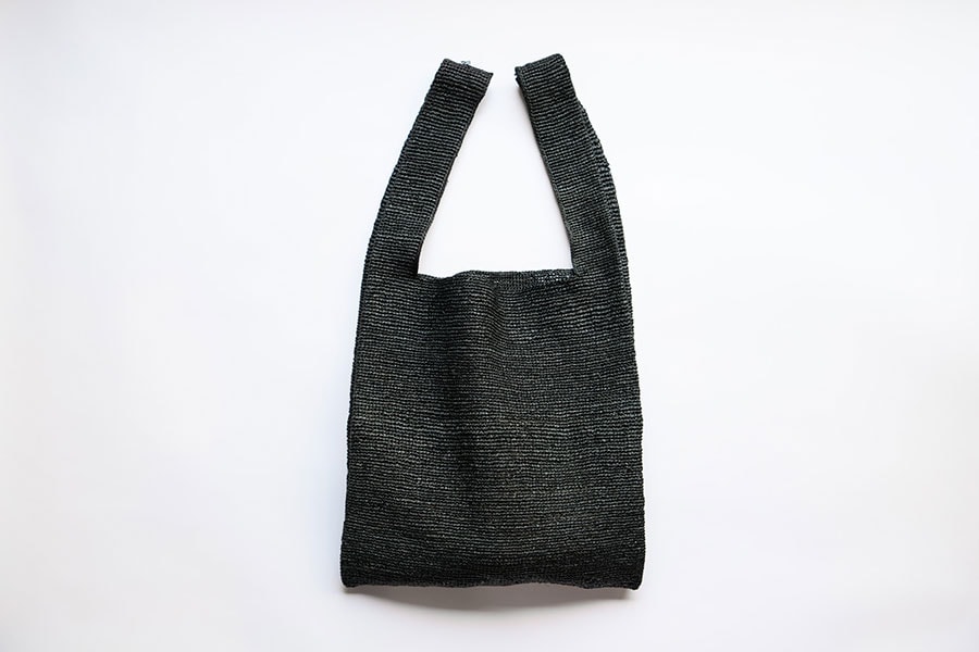 肩にかけられる＆無駄のないシンプルなデザインが気に入って購入したラフィアバッグ。黒は「ロク」の別注。「収納力抜群で内ポケット付き。仕事の日も重宝しています」