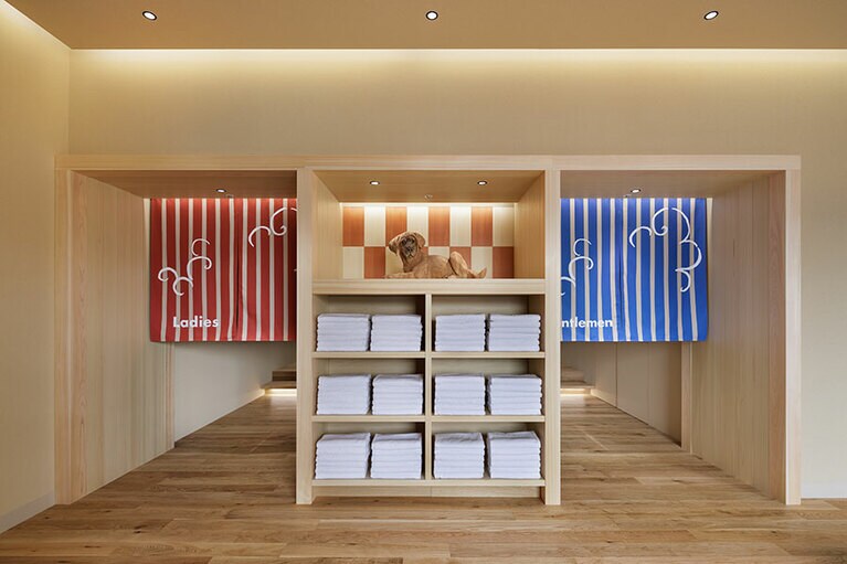 番台をイメージした入口では木彫りの土佐犬（はしもとみおさん作）がお出迎え。