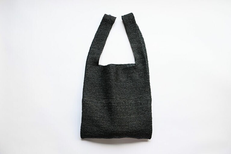 肩にかけられる＆無駄のないシンプルなデザインが気に入って購入したラフィアバッグ。黒は「ロク」の別注。「収納力抜群で内ポケット付き。仕事の日も重宝しています」