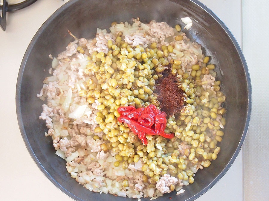 （3）赤身がなくなったら、（1）の玉ねぎを入れて炒めます。玉ねぎがしんなりしてきたら、チリパウダー、トマトペースト、茹でた緑豆を入れて炒めます。