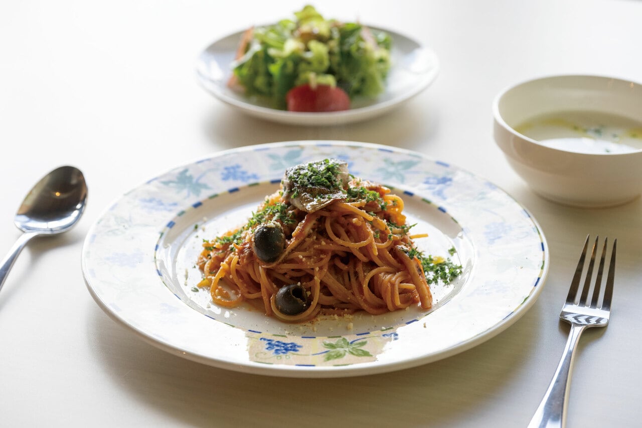 サラダとスープが付いた「佐渡産魚介とオリーブのトマトソースパスタ」1,300円。