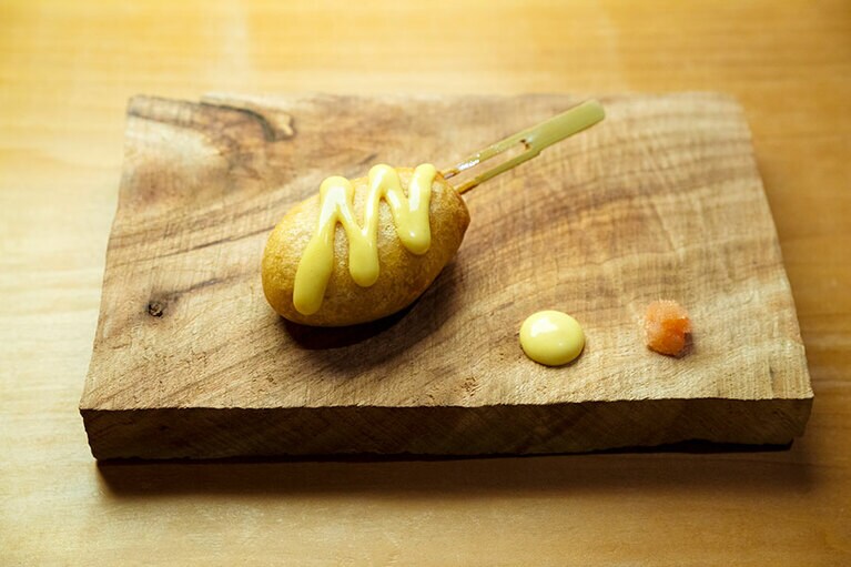 からし蓮根をイメージした「クマモトドッグ」。擦った蓮根を練り込んだもちもちの生地に炊いた蓮根がゴロッと入っており、食感も楽しい。からし味噌マヨネーズとの相性も抜群。