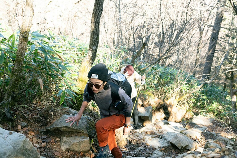 ポールがない場合は、佐竹さんのように岩に手をついて全身のバランスを取ると登りやすい。