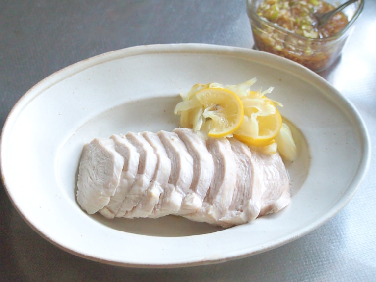 鶏肉が冷めたら、食べやすい大きさに薄切りにし、器に並べる。野菜や出てきた煮汁をサイドに盛り付ける。