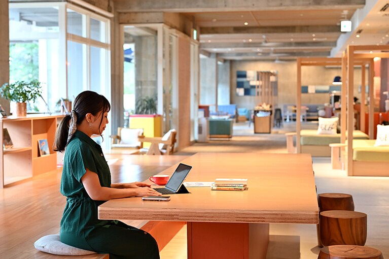 HafHコインで宿泊できる人気リゾート「星野リゾート　BEB5沖縄瀬良垣」での滞在を、CREAアンバサダー佐藤由樹さんが体験。沖縄にまつわる本やボードゲームなどが用意され、楽しい時間を過ごせるパブリックスペース「TAMARIBA」にて。