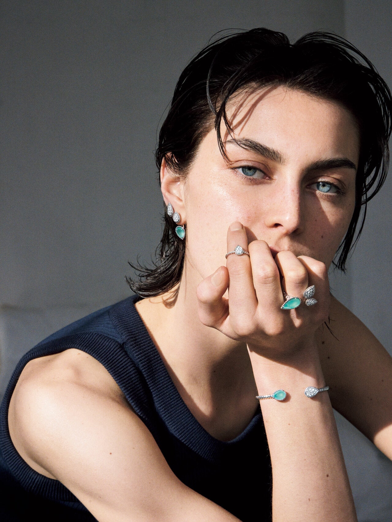 「セルパンボエム」イヤリング（下）2モチーフ シングル スタッズイヤリング（WG×アクアプレーズ×ダイヤモンド） 687,500円、（上）スタッズイヤリング スモール（WG×ダイヤモンド） 1,359,600円（両耳セット価格）、リング（人差し指）リング エクストラスモール（WG×ダイヤモンド） 566,500円、（薬指）3モチーフ リング（WG×アクアプレーズ×ダイヤモンド） 1,782,000円、ツイン モチーフ バングル（WG×アクアプレーズ×ダイヤモンド） 1,372,800円（すべて予定価格）／ブシュロン（ブシュロン クライアントサービス 0120-230-441）　タンクトップ 15,400円／ポステレガント（ポステレガント 03-5738-8507）