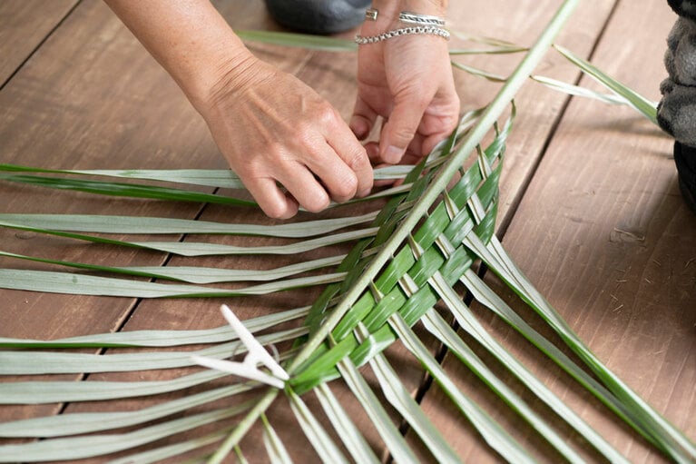 ご近所さんからいただいたというマーニを使用した、ナチュラルリーフクラフトを体験。葉を一枚一枚編んでいきます。