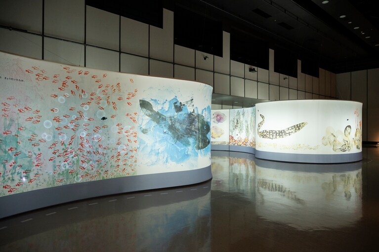 スクリーンの映像がゆったりと切り替わる。「レオ・レオーニの絵本づくり展」展示風景、ヒカリエホール、2025年