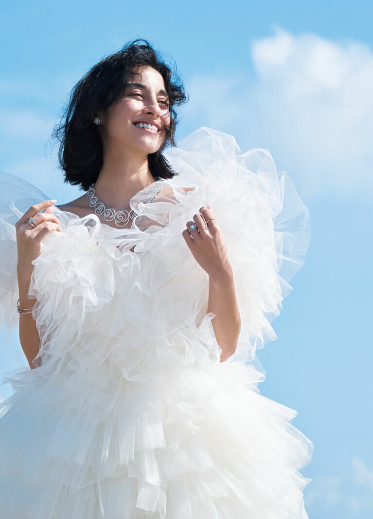 イタリア語で“つぼみ”を表す「ボッチョーロ」の魅力は、その名の通り、花が咲き始めるころの新鮮さや可憐さ。お揃いのネックレスや、同じく花モチーフで人気の「マルゲリータ」のピアスを合わせて、よりロマンティックに、華やかに。 
〈左手・薬指〉「ボッチョーロ」エンゲージリング（PT×センターDIA0.3ct～）677,600円～〈左手・人差し指〉「ヴェラモーレ」マリッジリング（YG×DIA）185,900円 〈右手・指先から〉「マルゲリータ」リング（WG×DIA）627,000円 「ペルセンプレ」リング（PG×DIA）413,600円 「ボッチョーロ」ネックレス（WG×DIA）14,014,000円 「マルゲリータ」ピアス（WG×DIA）1,133,000円、バングル（PG×ブラウンDIA）559,900円、（WG×DIA）677,600円／すべてダミアーニ（ダミアーニ 銀座タワー） ミニドレス（参考商品）／ミリア ロンドン（ドレッシーズ スタジオ アオヤマ）