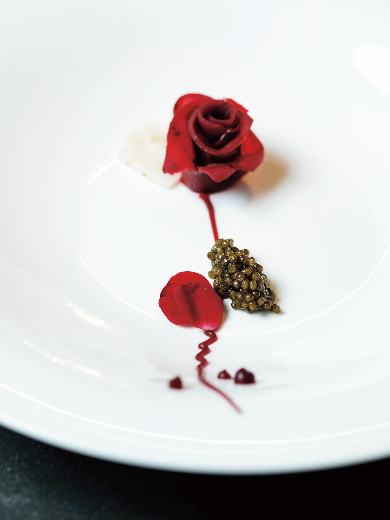 カンパリでマリネしたビーツにチョウザメとキャビアを合わせた薔薇を模したアミューズ。チョウザメの旨みと酸味のバランスに食欲がそそられる。