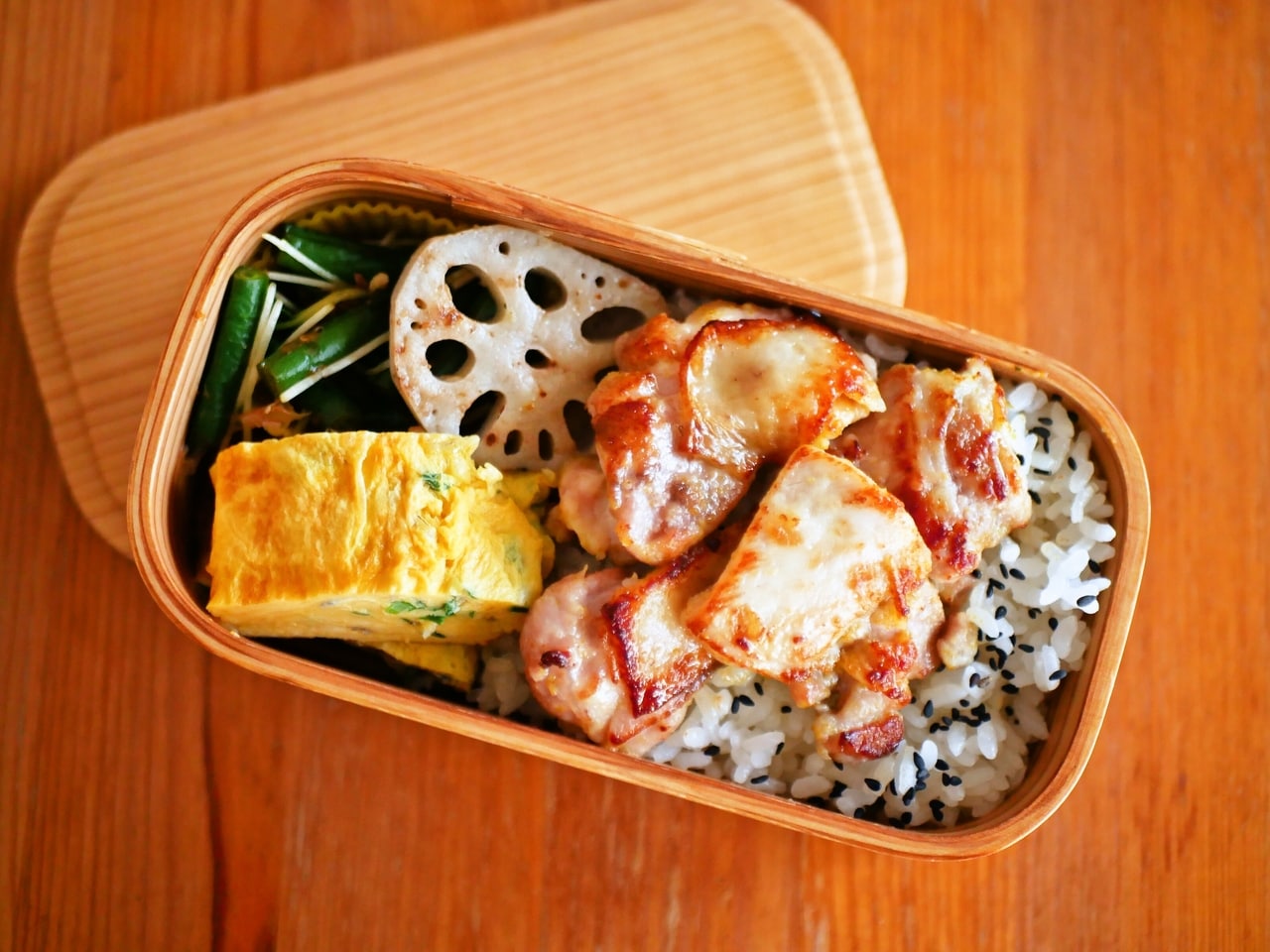 ある日のお弁当。カレー風味の鶏の焼いたの、ねぎ入り玉子焼き、素焼きれんこん、いんげんのおかか和え。