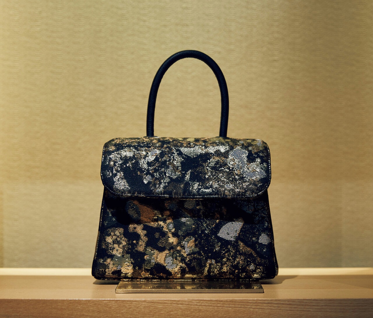 山々や大陸の岩盤層に着想して作られた布「Sediment」は、シルクや箔を用いた贅沢な素材。“キモノバッグ”330,000円。