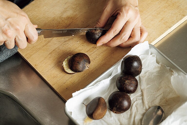 バットにペーパータオルを敷き、栗を鍋から数個ずつ取り出してのせ、水けをきってから切るとよい。