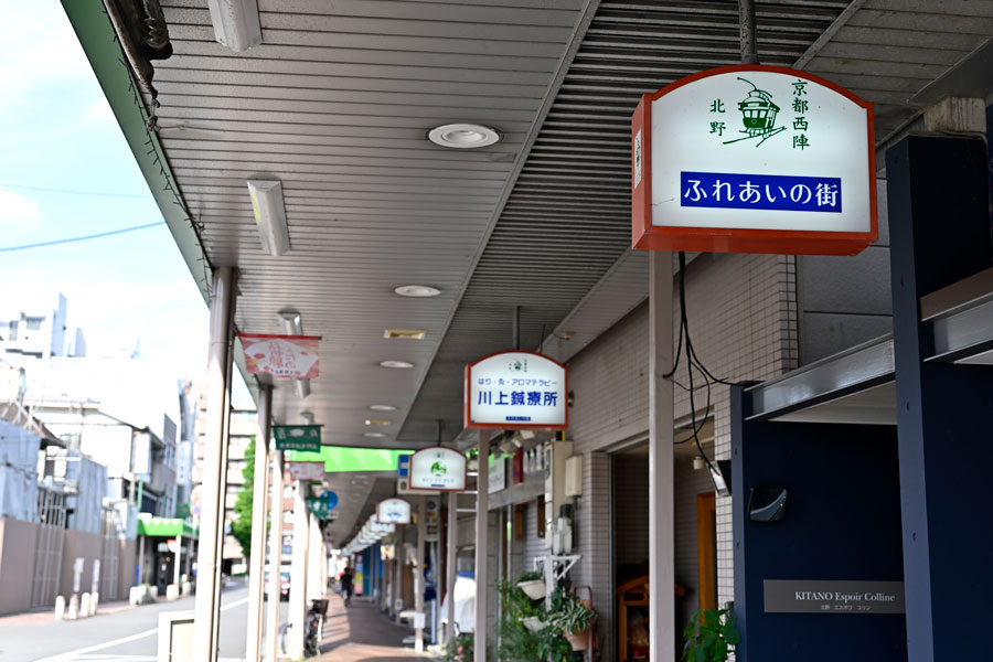 北野商店街。北野天満宮の南側に位置し「西陣の台所」として親しまれる。京都に日本初の市電が走った場所でもある。「妖怪ストリート」で街おこしする大将軍商店街へと続く。