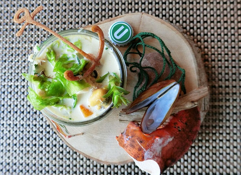 ボウルに入ったクラムチャウダーをイメージしていたら、こんなユニークな盛り付けで登場。テーマは「近くの海岸にあるもの」。木製プレートの上には、ロブスターの殻や漁師網、地ビールの蓋が。