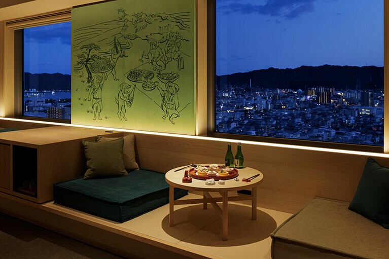 窓辺に小上がり風の居間スペースを設けた「うたげセミスイート」。