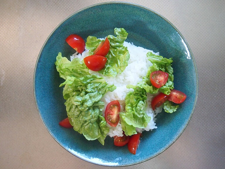 （5）器に、ご飯、ミニトマト、手でちぎったグリーンリーフを飾ります。