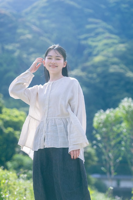 豊かな自然に恵まれた、徳島県美馬市。市を囲む山は季節ごとに姿を変え、春は桜、夏は新緑、秋は紅葉、そして冬は雪化粧をした姿も。リネン天然染めギャザーブラウス（OFF WHITE）30,800円、リネンデニムワイドジーン（BLACK）33,000円／ネストローブ
