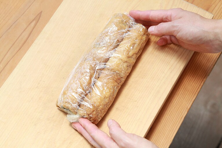 巻き終わったらラップで包んで形をなじませると切り分けやすく、また味もなじむ。