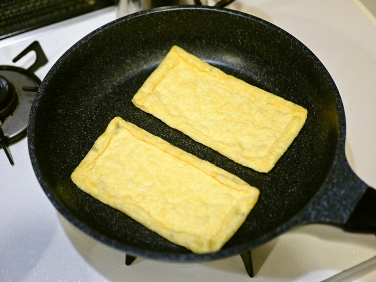 フッ素樹脂加工されたフライパンを中火で熱し、油揚げを片面4分ずつ焼いていきます。