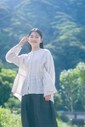 豊かな自然に恵まれた、徳島県美馬市。市を囲む山は季節ごとに姿を変え、春は桜、夏は新緑、秋は紅葉、そして冬は雪化粧をした姿も。リネン天然染めギャザーブラウス（OFF WHITE）30,800円、リネンデニムワイドジーン（BLACK）33,000円／ネストローブ