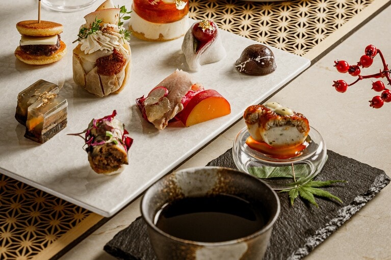 写真手前は、アミューズ「うなぎと銀杏のプティテリーヌ」とウェルカムティーの極上ほうじ茶。奥は、日本茶との調和を楽しむメニューの数々。