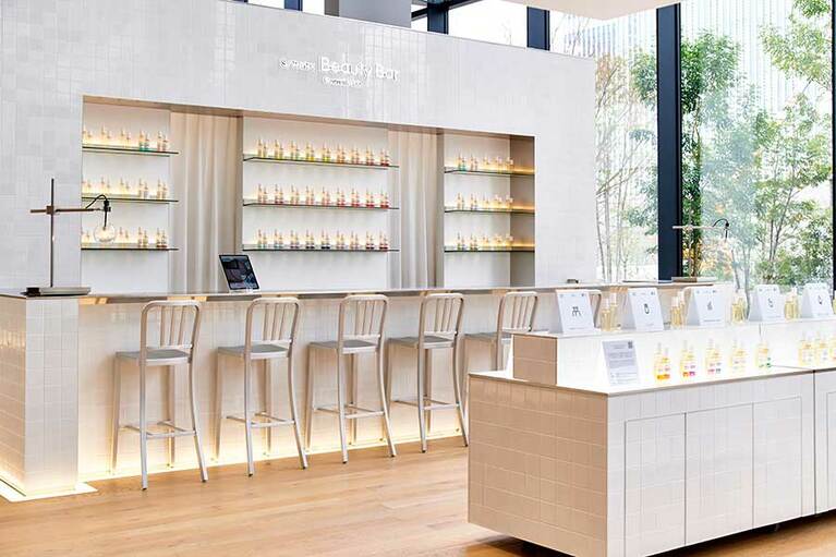 【資生堂グローバルイノベーションセンター S/PARK(エスパーク)】各種サービスの受付を行うコンシェルジュカウンターは白を基調としたクリーンな雰囲気で、カウンターにハイチェアというバーをイメージした空間。