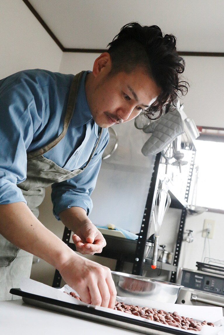 焙煎したカカオを選別する丈池さん。
