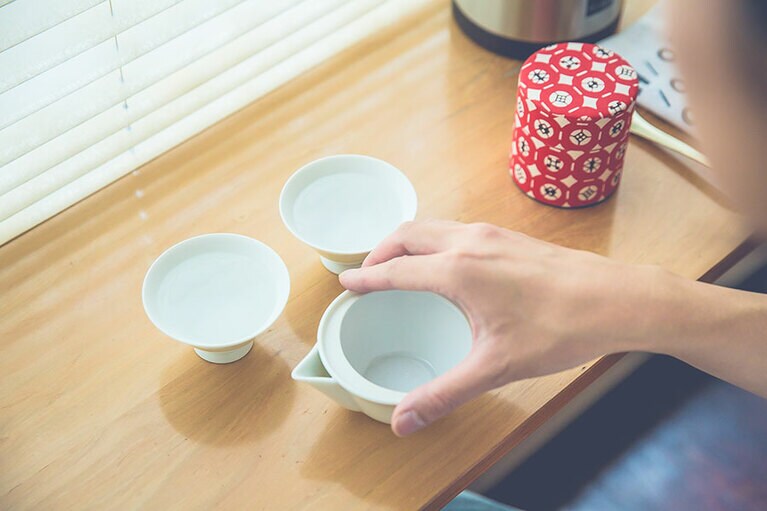 ［おいしい日本茶の淹れ方］(2) 湯のみにお湯を入れる。お湯は1回別の容器に移動すると、10度ほど温度が下がると言われており、一度沸騰させたお湯をポットに、さらに湯のみに移すことによって80℃まで湯温を下げる。
