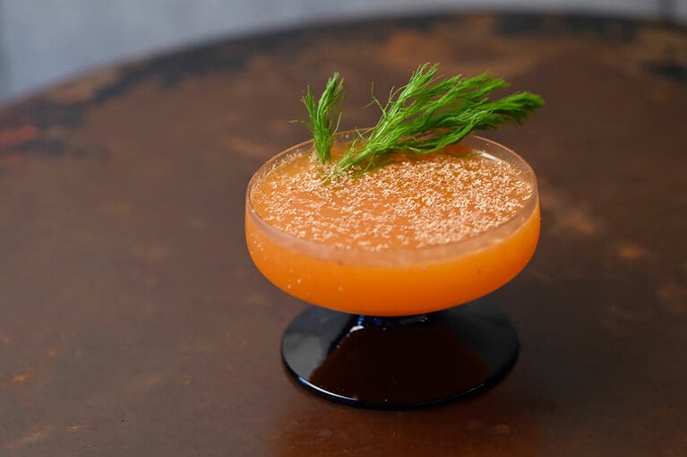 『ラビットファクトリー』1,500円。通年味わえるシグネチャーカクテル。キャラウェイシードの風味をつけたラムに、人参で作った自家製コールドプレスジュースを合わせて、ナツメグを削りかける。さらりとした飲み口で、人参の自然な甘さを感じる。フェンネルがあしらわれ、見た目も人参みたい！