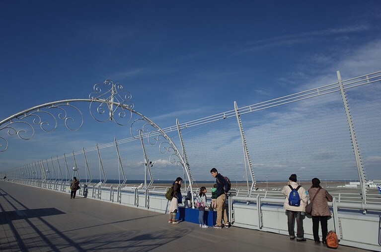 スカイデッキに出て、右側は国内線、左側は国際線。一眼レフで熱心に写真を撮る中高年の方も見受けられた。