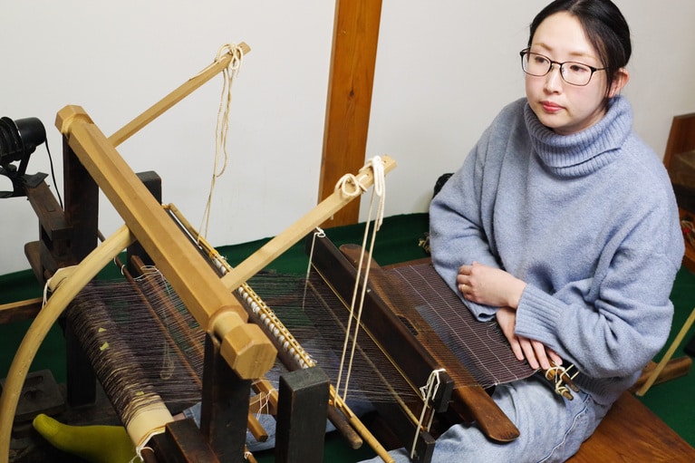 越後上布を手織機のひとつである居座機（いざりばた）で織る。越後上布と認められるためには、国指定 重要無形文化財とあってカラムシを手摘みした本製糸を使うことや、居座機で織る、雪晒しをすることなどさまざまな条件がある。