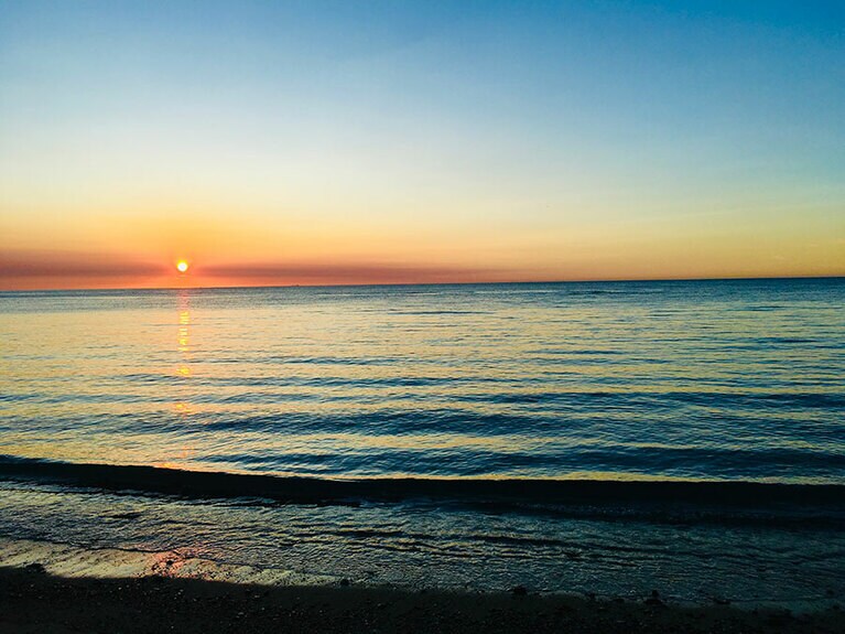 広大な水平線に沈みゆく夕日。