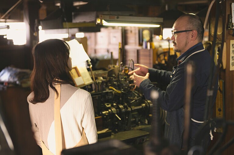 金属活字の説明をする佐々木さんと影山さん。