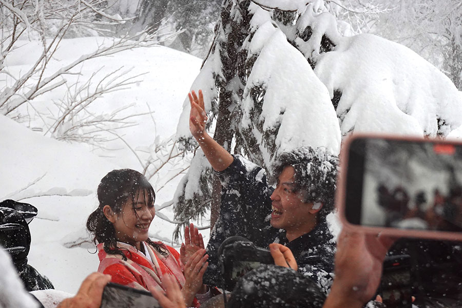 崖下で待っていた妻、優美さんが雪を払う。