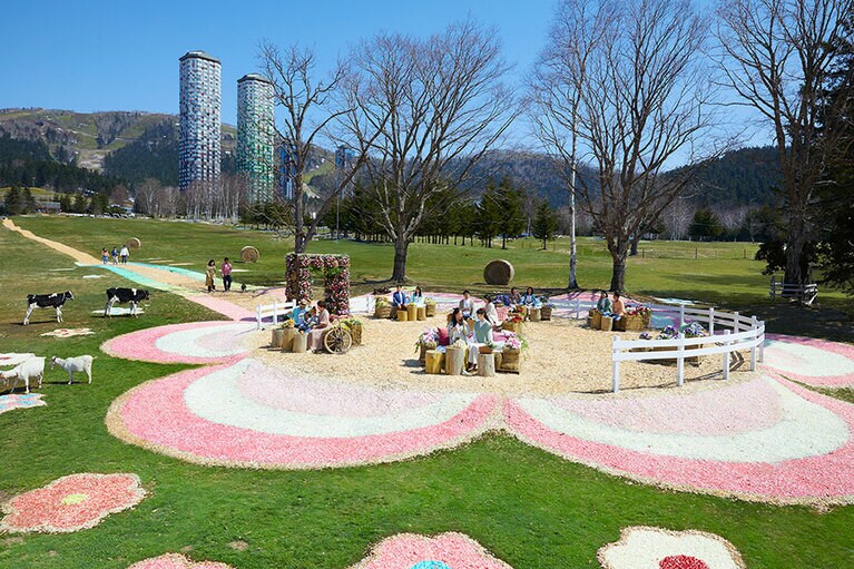 春めいた陽射しのもと、巨大な花やファームエリアの動物たちを眺めながらのんびりと過ごす。ファームエリアで提供される「花咲くティラミス」は600円、ドッグランを駆け回る愛犬のためのクッキーが600円。