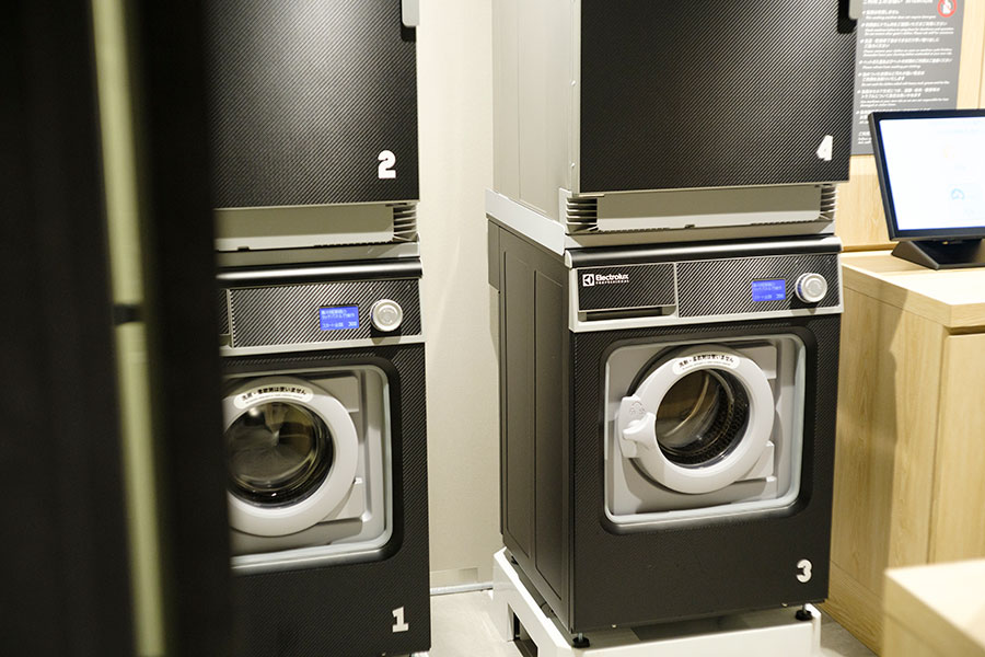 洗濯乾燥機・スマートランドリー「wash+comfort」。アルカリイオン電解水「wash+ウォーター」で洗い上げる、自然に優しい仕様です。洗濯35分／300円、乾燥15分／100円。