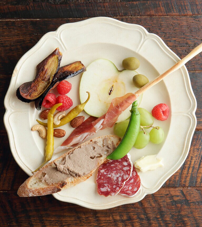 レバーペースト、薄切りのナスをカリカリに素揚げした“ナスのフライ”、生ハム＆グリッシーニなど。リンゴもこんな風に切ると食べやすく盛りつけても愛らしい。