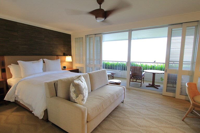 オーシャンフロントルームの室内。大きなソファとライティングデスクがある。ラナイの広さは約8平方メートル。