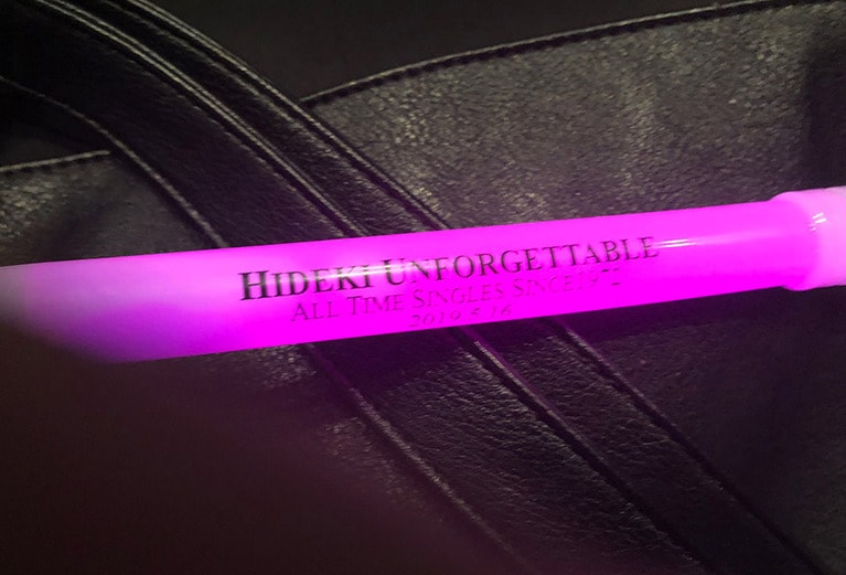 「HIDEKI UNFORGETTABLE」と書かれたサイリウム。ブルースカイブルーのブルーを買おうと思っていたのに、なぜか勢いで「ピンク」と注文していた自分がよくわからない。