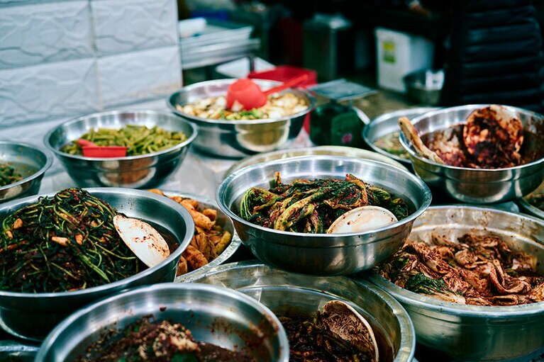 忠武洞夜明け市場のおかずの店にはニラやホウレンソウのナムルが並ぶ／国際市場（クッチェシジャン／국제시장）