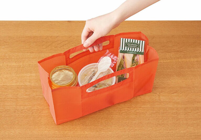 「パッタン」コンビニエコバッグ Sサイズ(バッグ使用時：W29.5×D12×H14cm、折りたたみ時：約W15.5×D0.4×H7.3cm) 1,000円。カラーはピンク、オレンジ、ミドリ、グレーの4色展開。