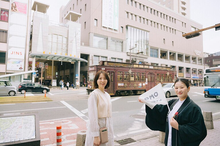 上通り商店街方面へいざ出発。熊本城を横目に渡るホテル目の前の道路を、路面電車が通過していく。