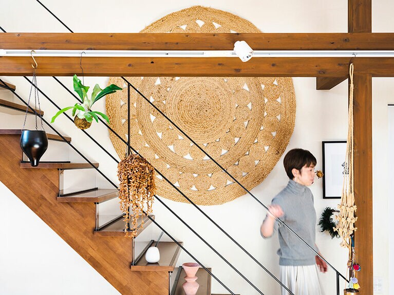 階段の壁に大胆に掛けられた「Orné de Feuilles(オルネ ド フォイユ)」で購入したラグ。